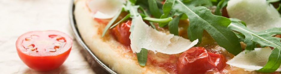 Pizza mit Ruccola und Tomaten