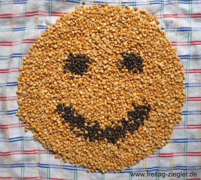 Smiley aus gelben Erbsen und Puy-Linsen