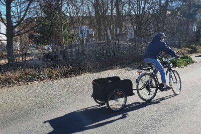 Junge Frau mit Fahrrad und Anhänger