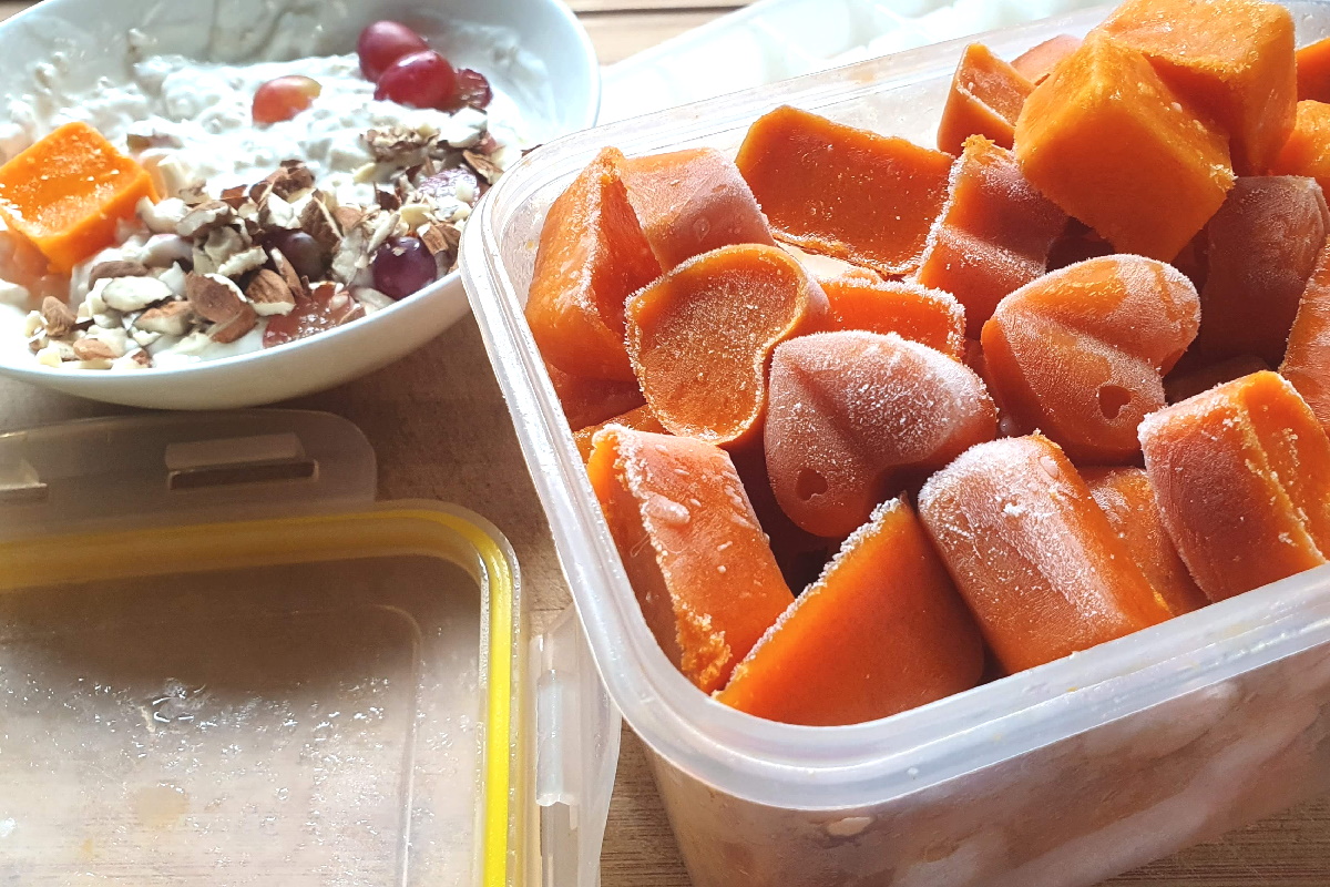 Box mit gefrorenem Sanddornsaft in Eiswürfelform, daneben eine Müsli